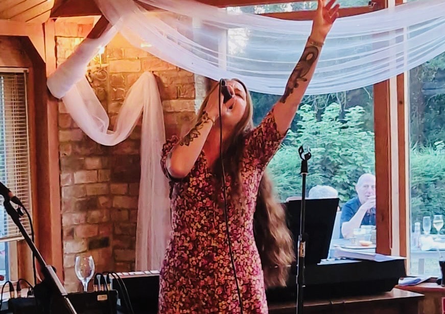Singer performing at a Voice Junction Adult Pop-Up Night in a local venue